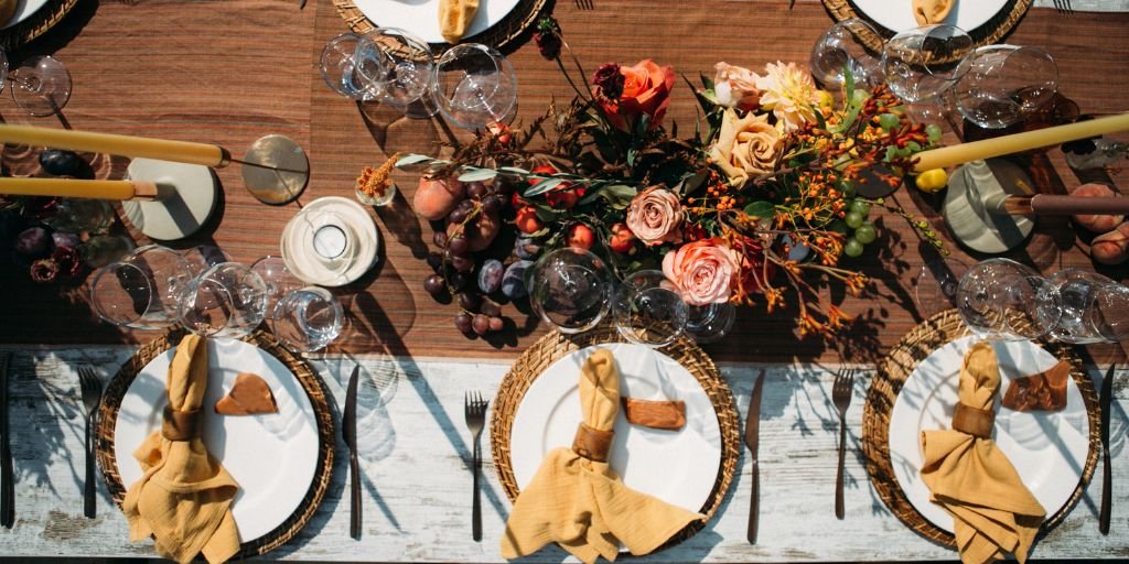 Autumn wedding table with earthy tones, orange flowers, and rustic decor.